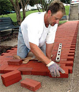 A bricklayer, laying bricks.